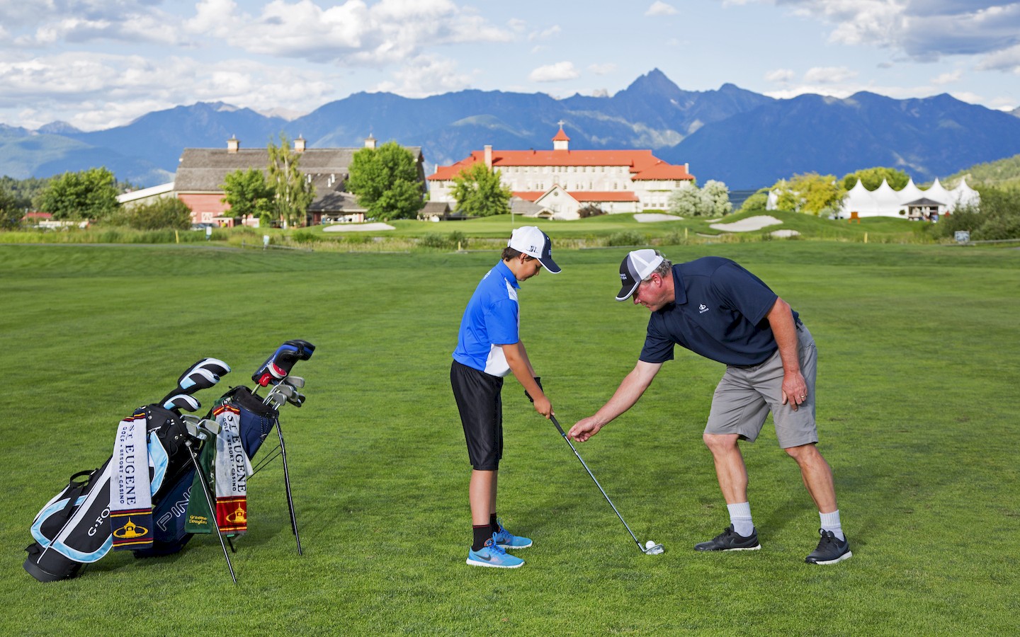 Father teaching son to golf