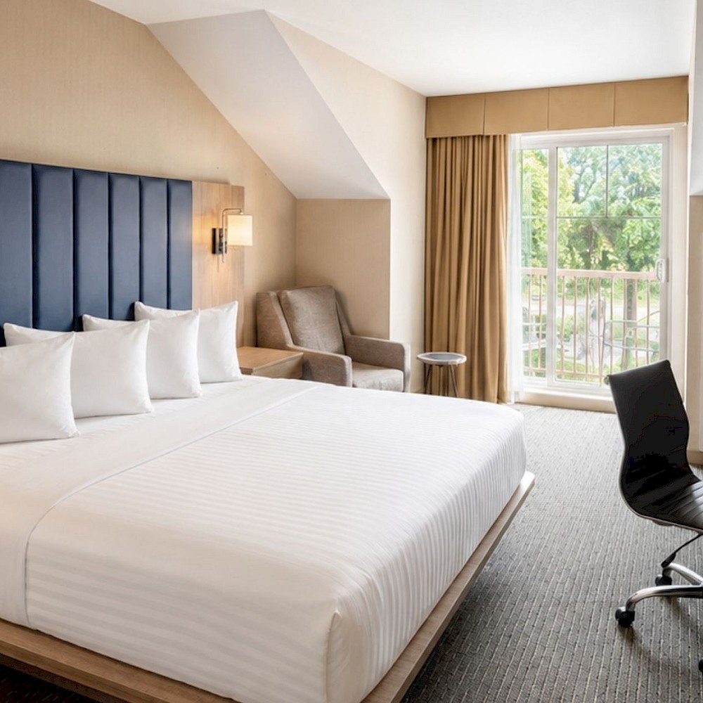 King hotel room with a work desk and a private balcony.
