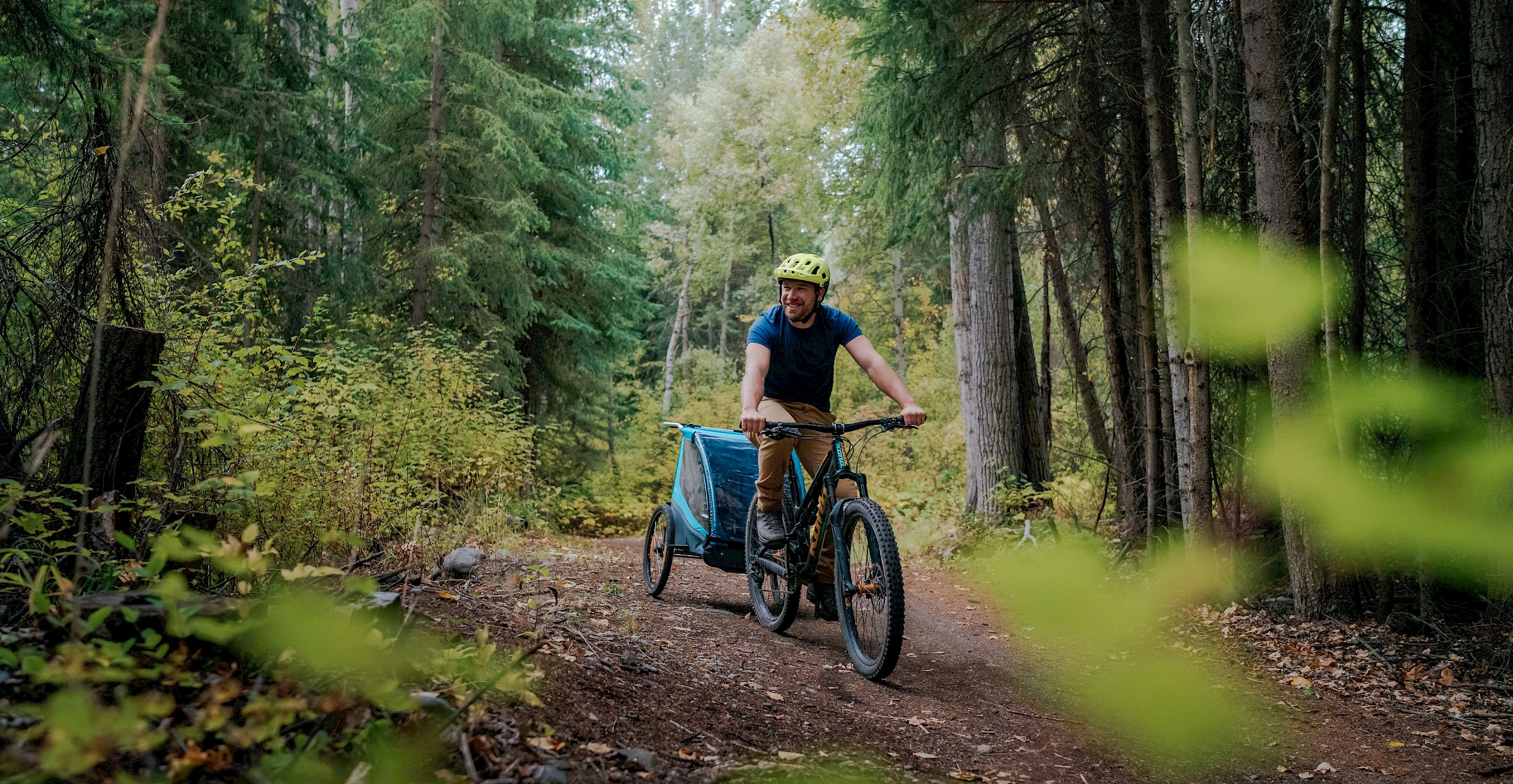 Father biking on wooded trail